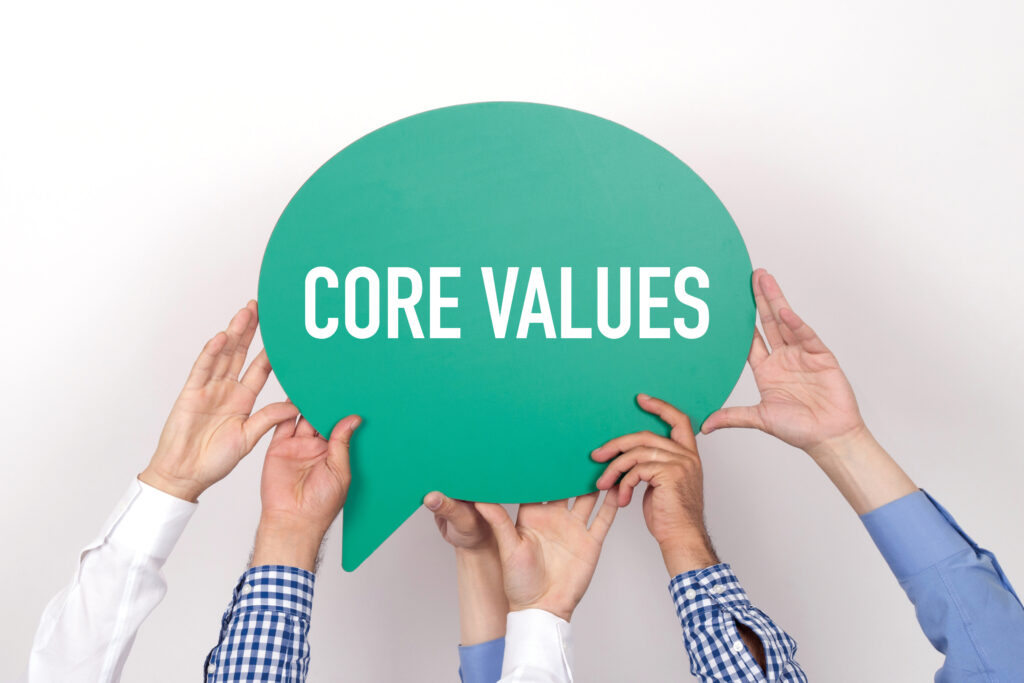 Three sets of hands holding a green speech build with the words CORE VALUES written
